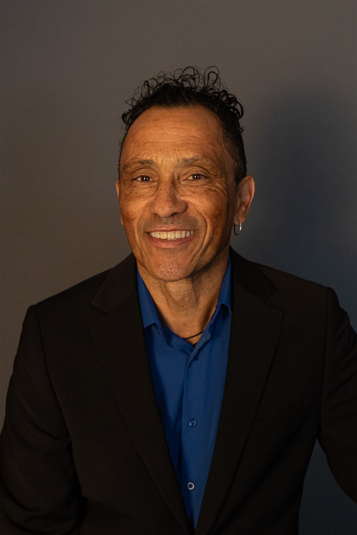 Professional headshot of Glenn Marais in a black jacket and blue shirt
